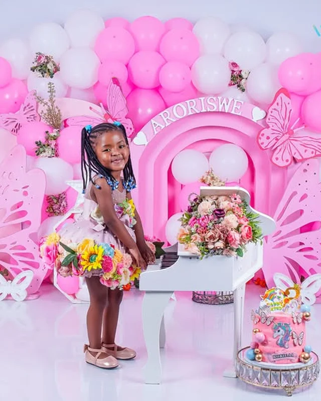 Birthday photoshoot at a toy piano, floral arch backdrop