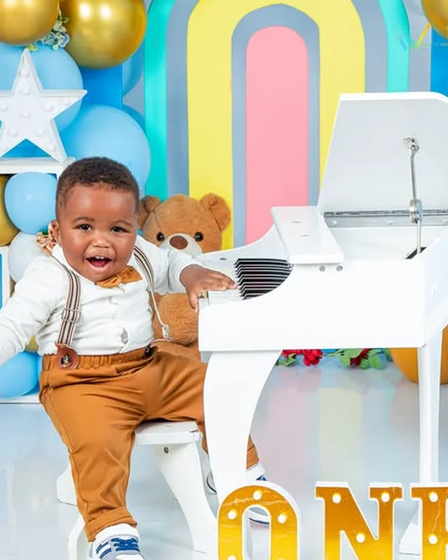 First birthday photoshoot at a toy piano with a teddy bear