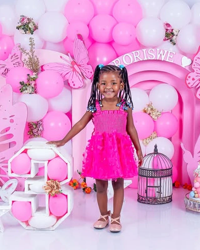 3rd birthday photoshoot, girl in a hot pink dress with a butterfly balloon arch