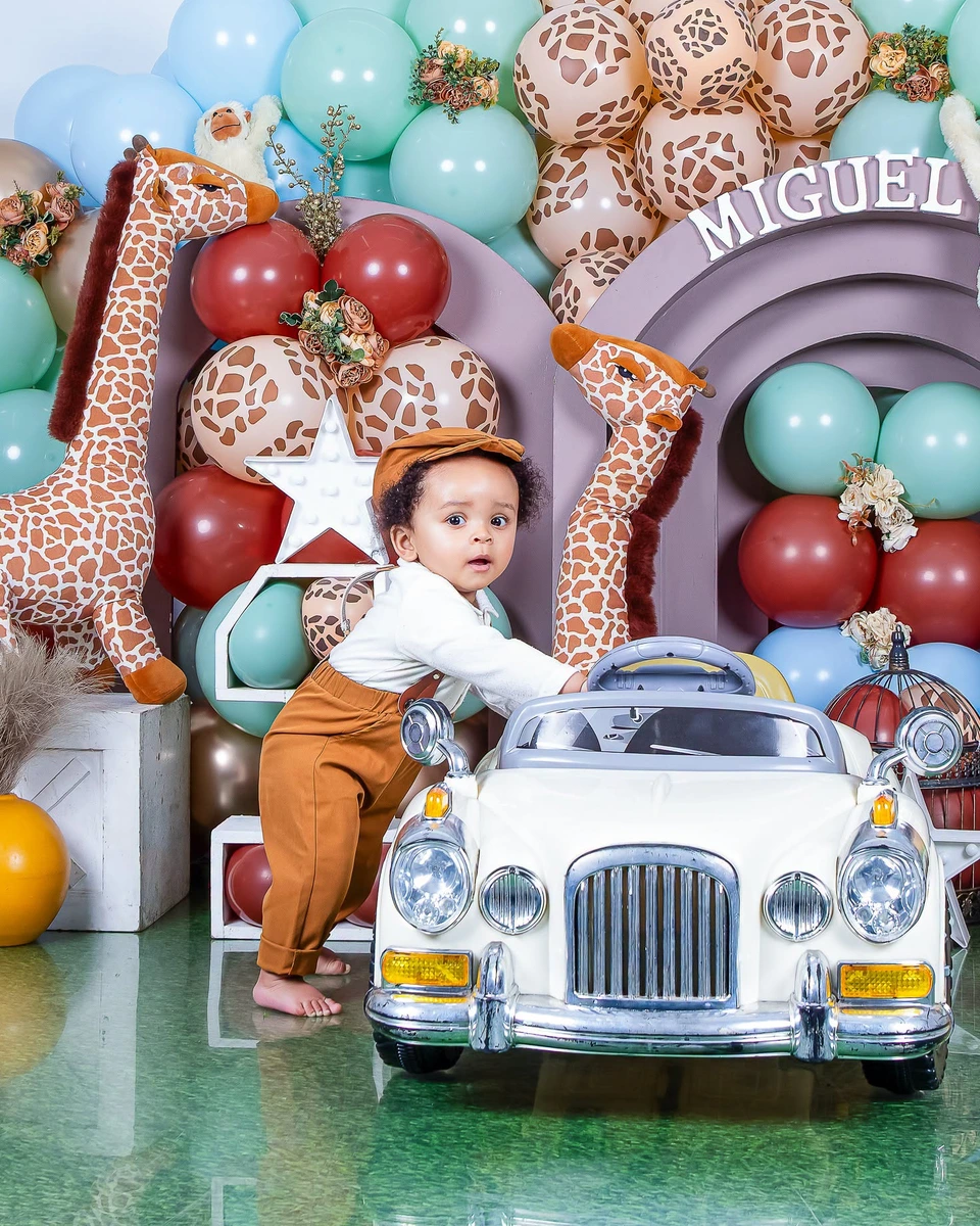 First birthday photoshoot, safari themed backdrop with giraffes and a toy car