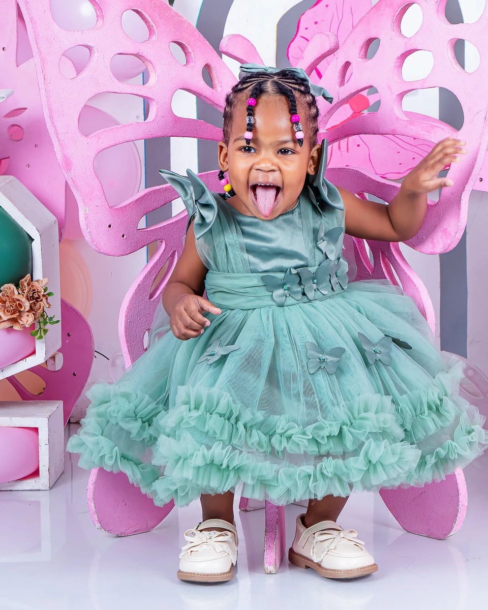 Birthday photoshoot, girl in a sage green dress on a butterfly throne chair